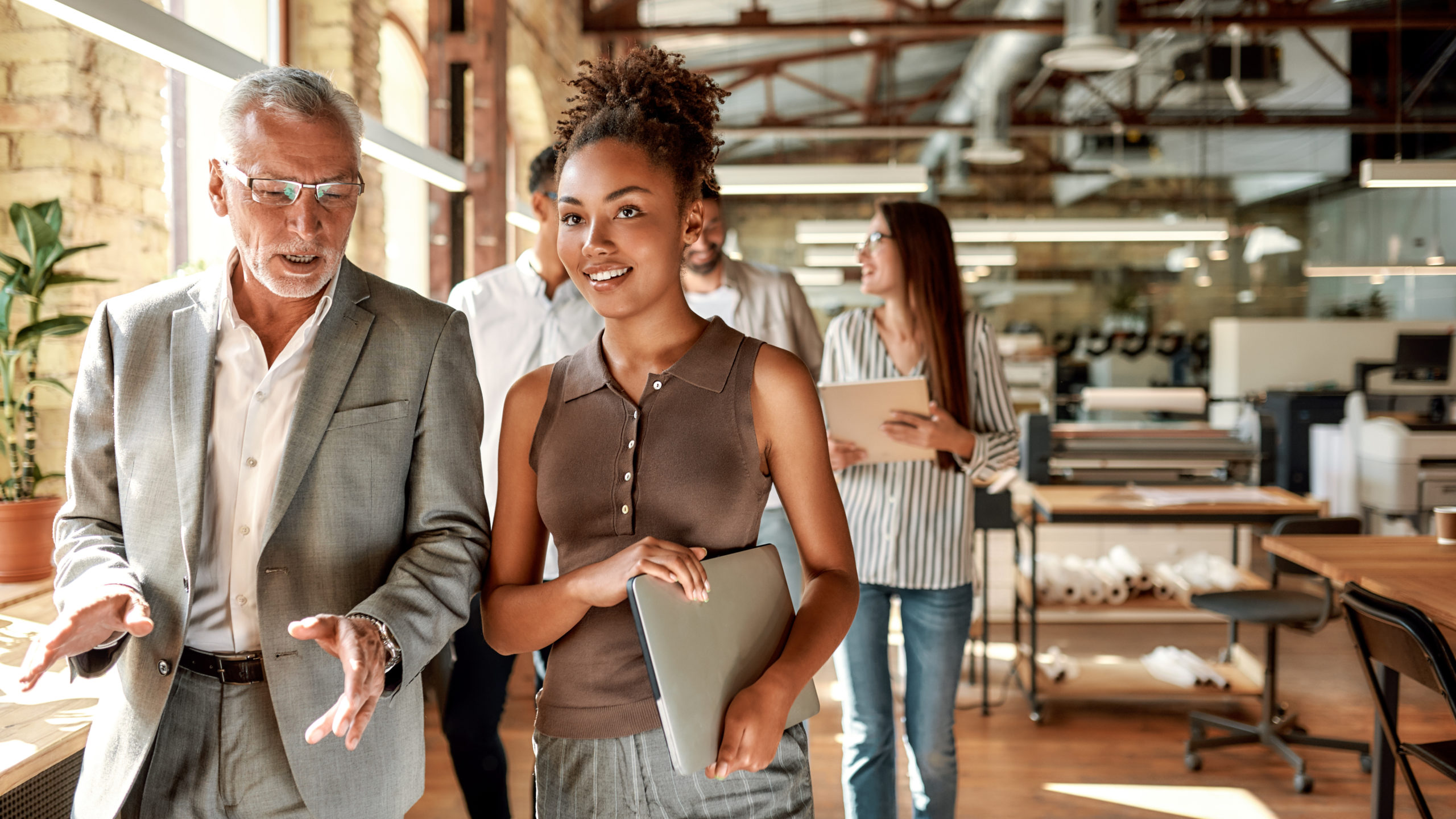 two talent management professionals in office walking and talking