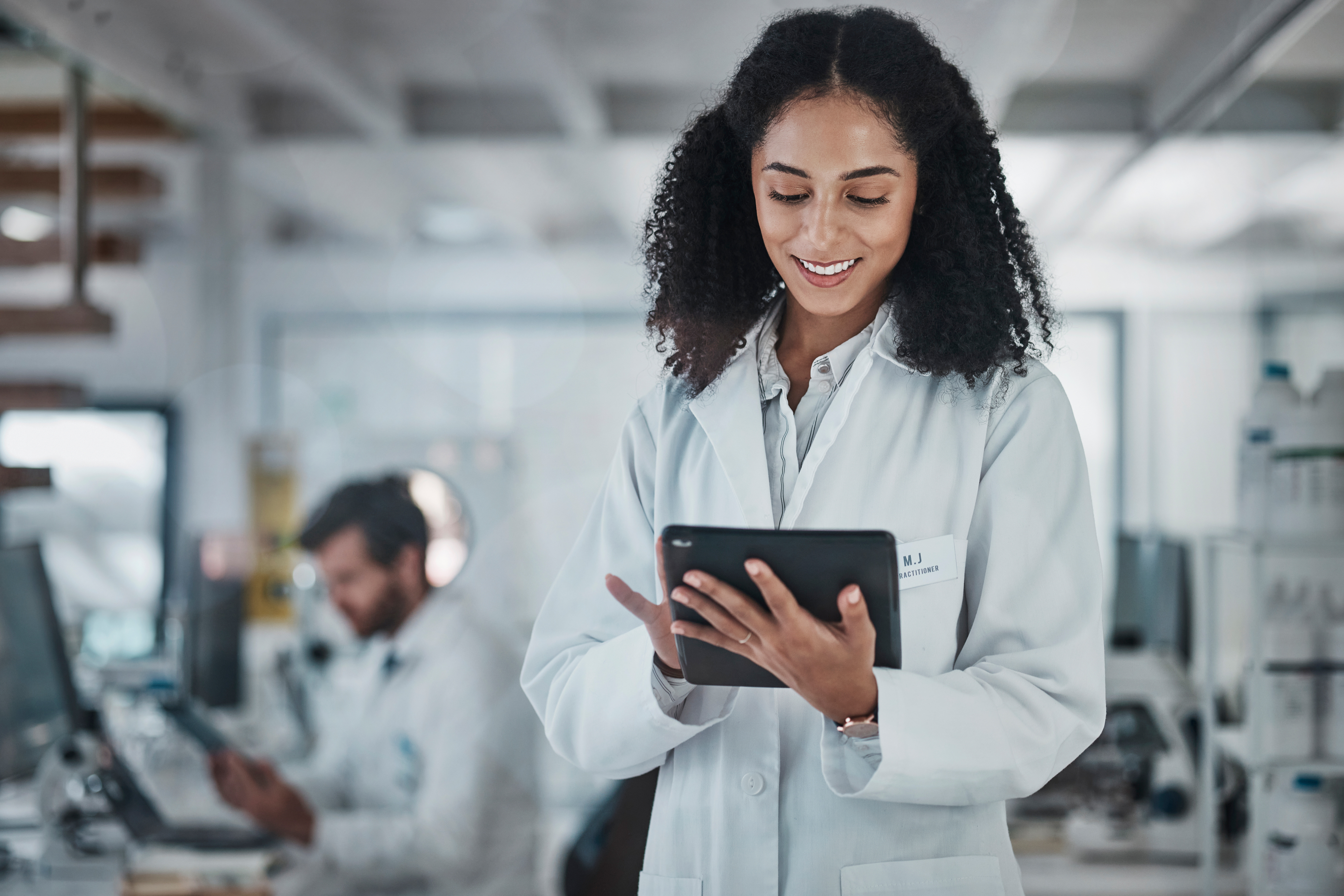 Science research and black woman with tablet smile and internet in laboratory with medical data Healthcare pharmaceutical innovation and scientist technology and reading email website or result - Search Solution Group Chemical engineering recruitment firm