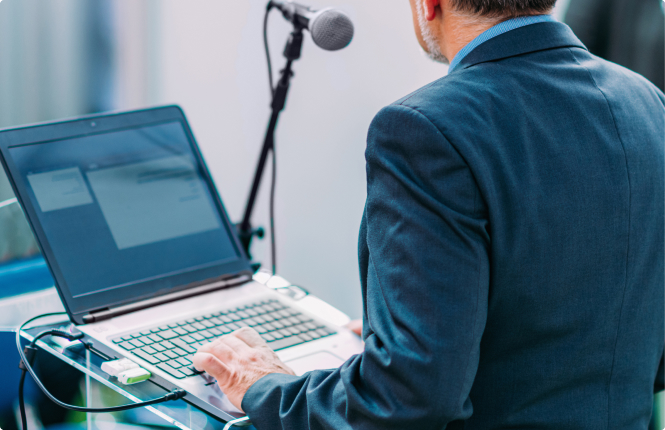 business professional presenting - Search Solution Group male pr professional presenting in-front of mic with laptop