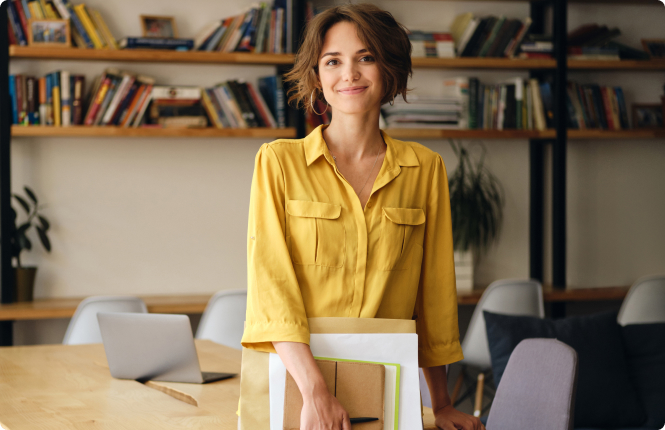yellow shirt marketing automation professional - Search Solution Group female marketing automation employee holding document standing