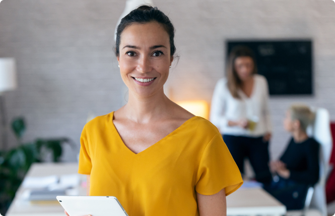 smiling female marketing leader in yellow shirt - Search Solution Group female marketing leadership professional holding tablet