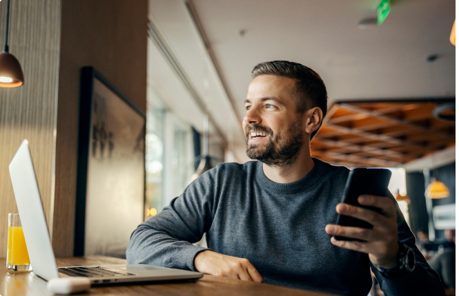 male marketing recruitment professional at desk holding phone - Search Solution Group male marketing recruitment professional working at desk