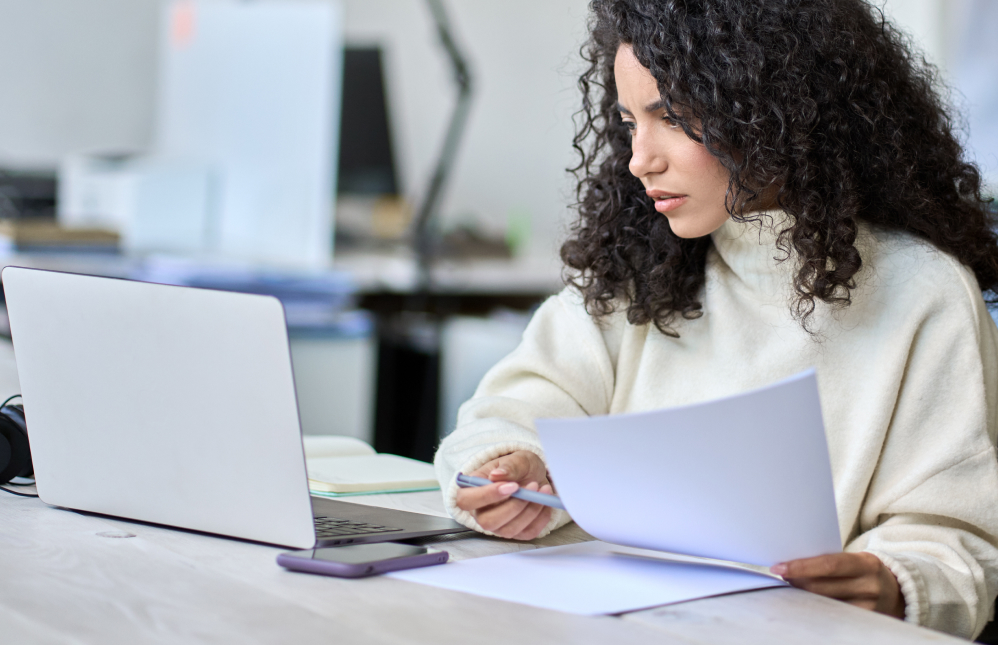 female accounts receivable on laptop in sweater