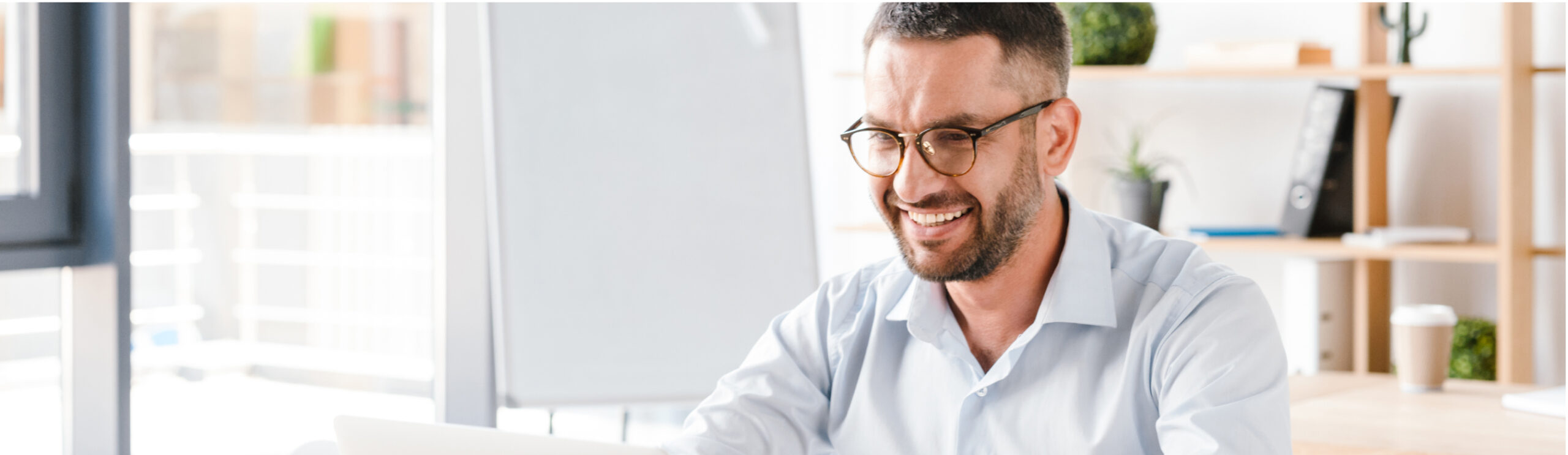 Employer on laptop smiling.