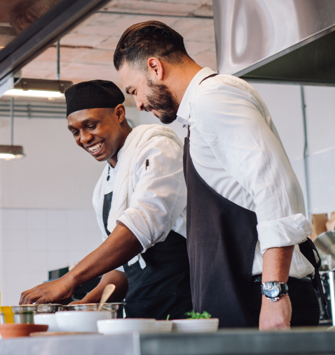 food and beverage candidate smiling food and beverage recruits cooking in a kitchen