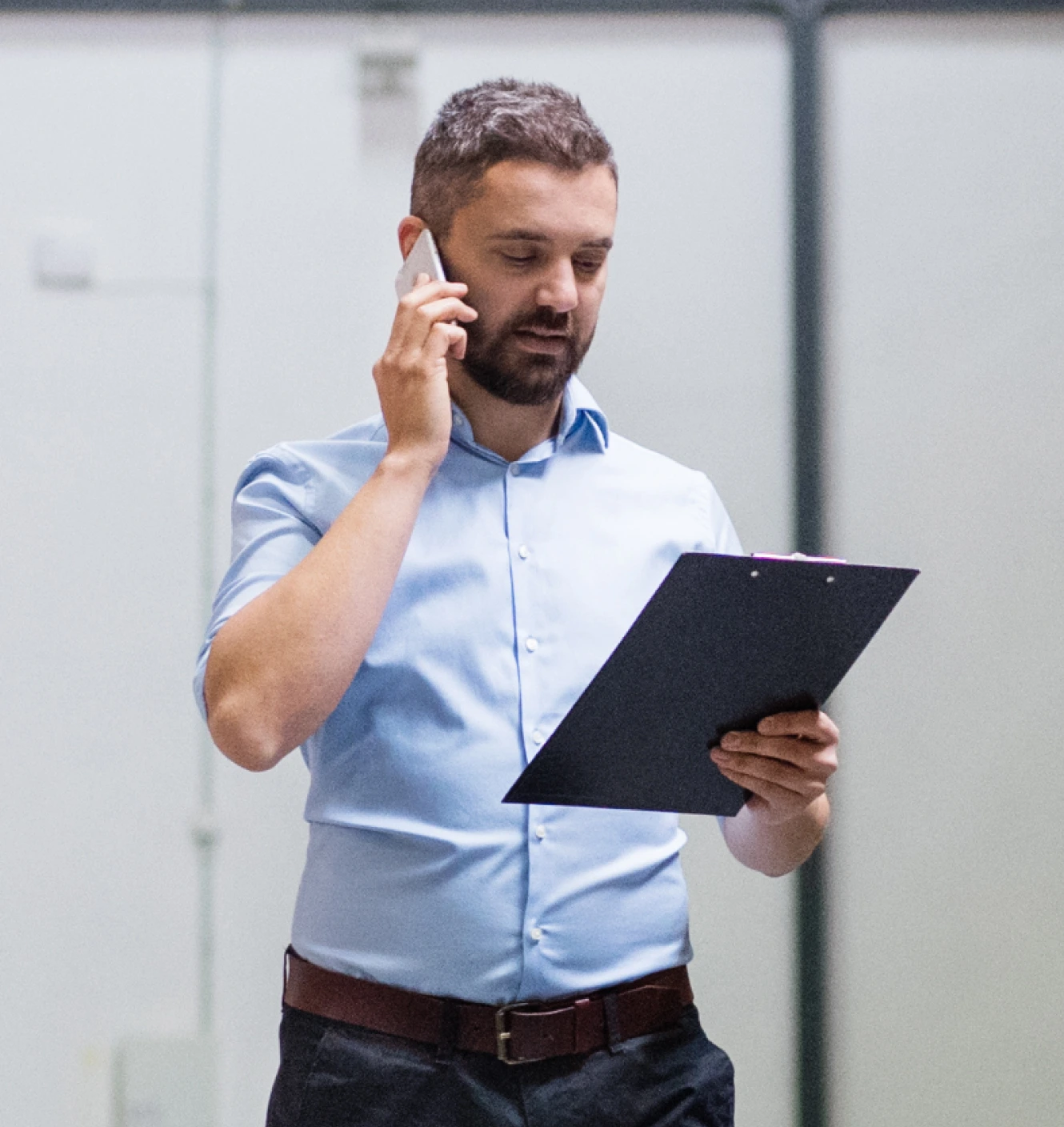 plant manager recruiter talking plant manager on phone in blue shirt